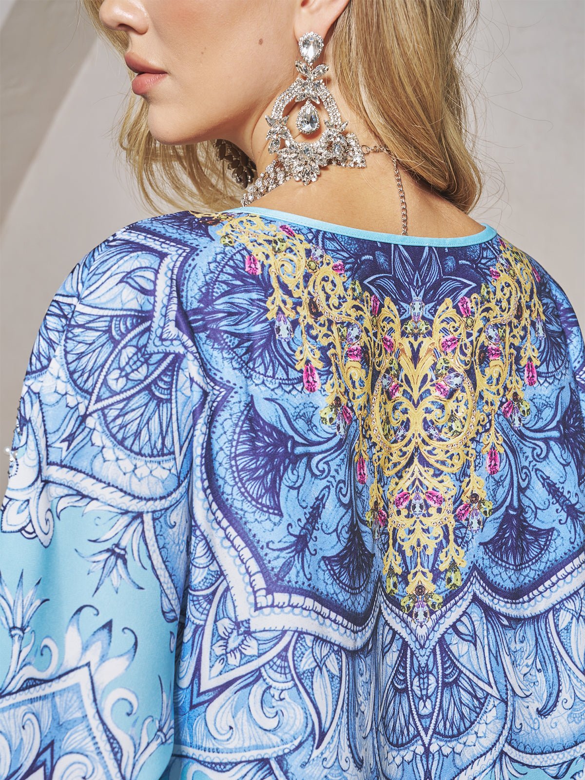 A woman models the Social Queen Beaded Baroque A-Line Dress, featuring intricate gold and purple back embroidery, shown from side and rear views, paired with large ornate earrings.