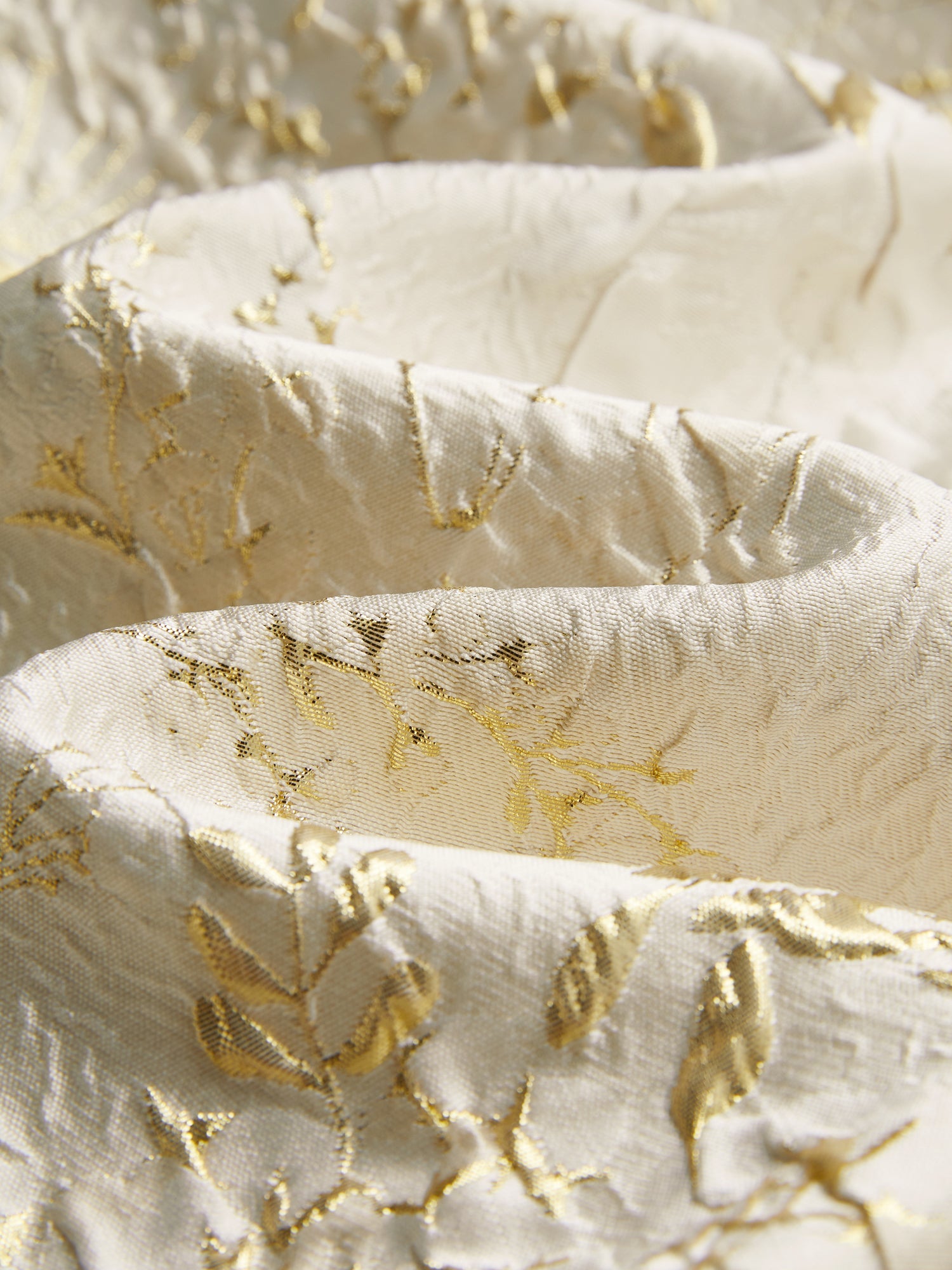 Close-up of the Beaded Jacquard Lantern Sleeve Jacket by Social Queen, featuring cream-colored fabric with gold floral embroidery, hand-applied beads, and textured folds.
