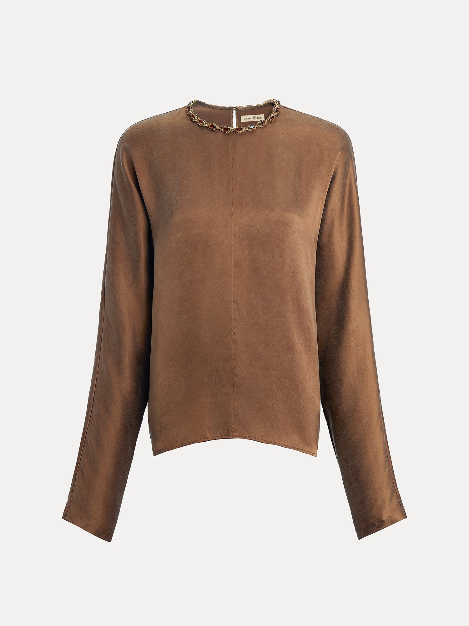 The Social Queen Crystal-Embellished Tencel Satin Blouse is a relaxed-fit, long-sleeve brown top with a round neckline detailed with hand-set crystals and a decorative chain, shown against a plain white background.