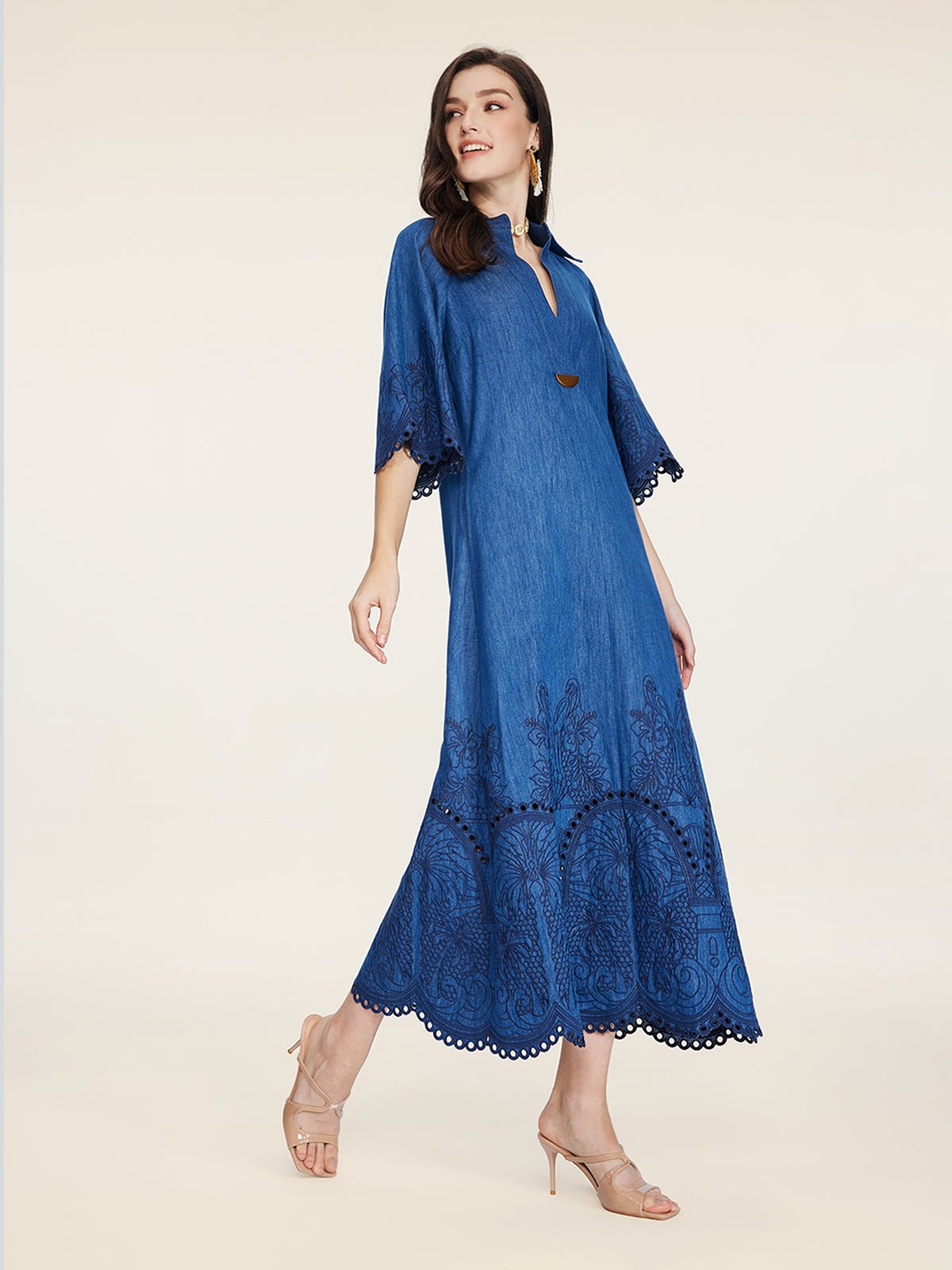 A woman wears the Social Queen Embroidered Jacquard Denim Dress—an ankle-length, blue denim dress with half sleeves and jacquard embroidery—paired with sandals against a plain light background.