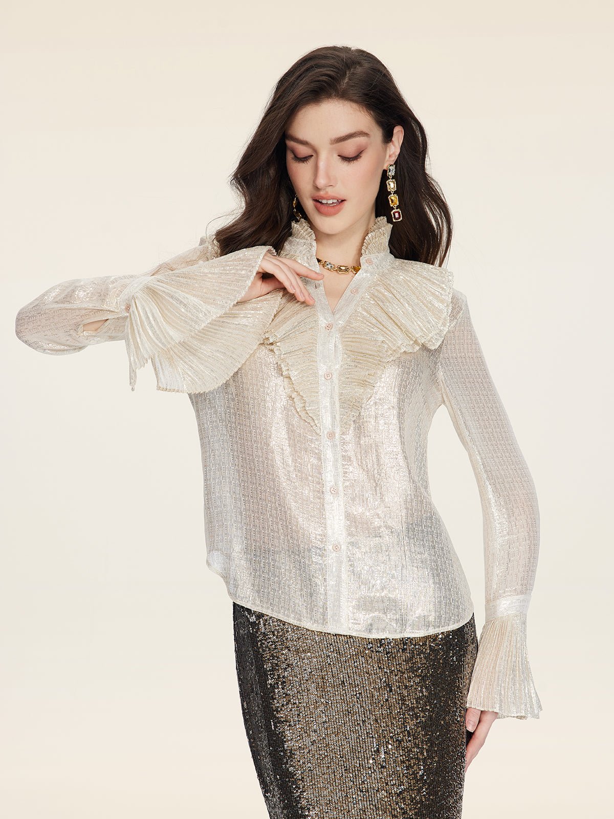 A woman models the Social Queen Ethereal Metallic Ruffle Silk Blouse—sheer silk with a ruffled high collar and shimmering gold threads—paired with a sequined skirt, against a plain light background.