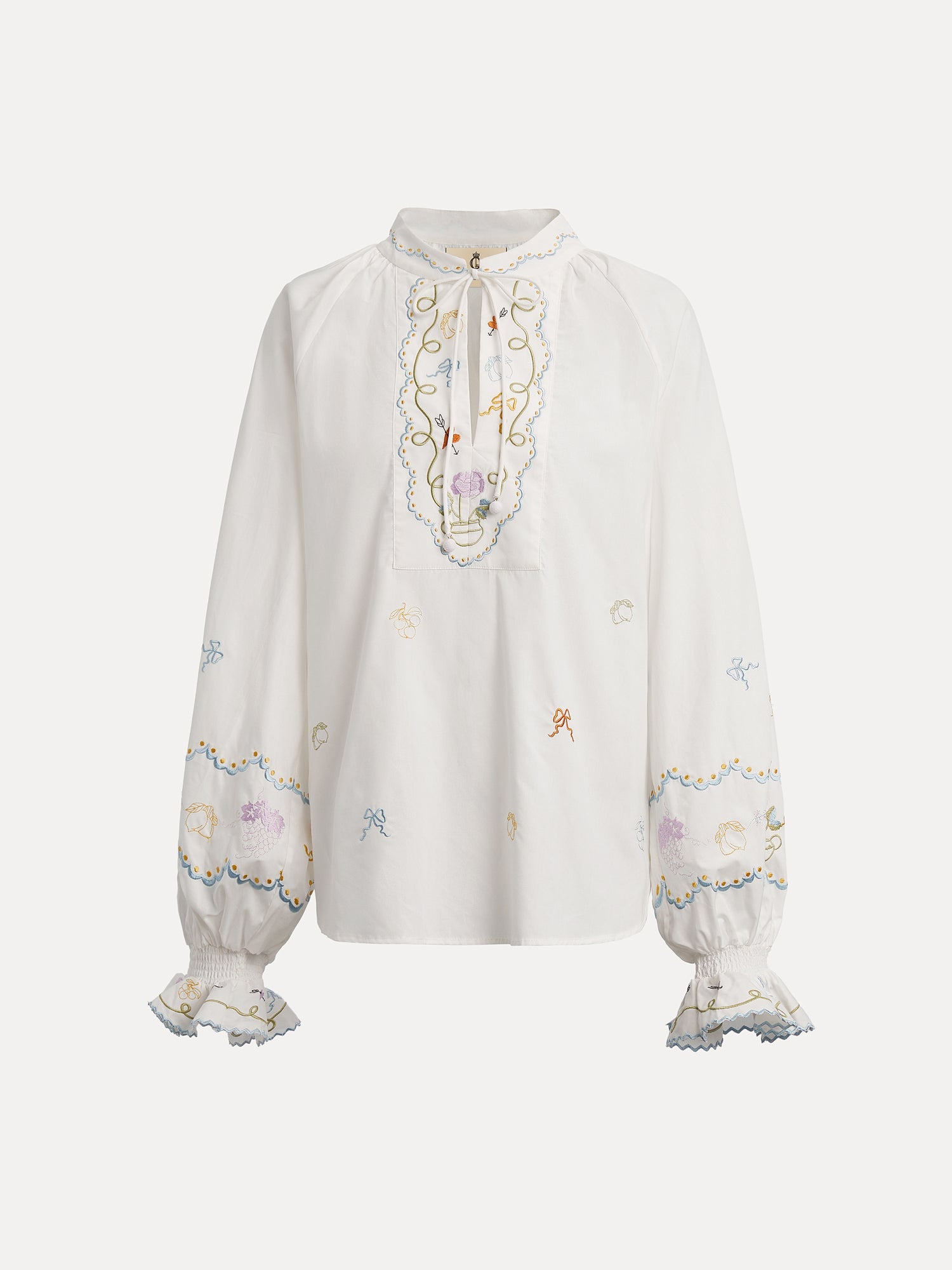 The Social Queen Floral Embroidered Cotton Blouse features a white long sleeve design with pastel embroidery, ruffled cuffs, and a tie-neck detail.