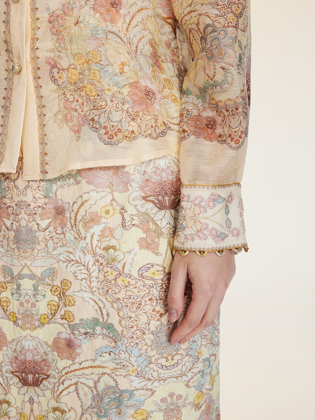 A person stands against a neutral background wearing Social Queen’s Floral Print Collared Blouse, featuring a cream color and intricate paisley-inspired design.