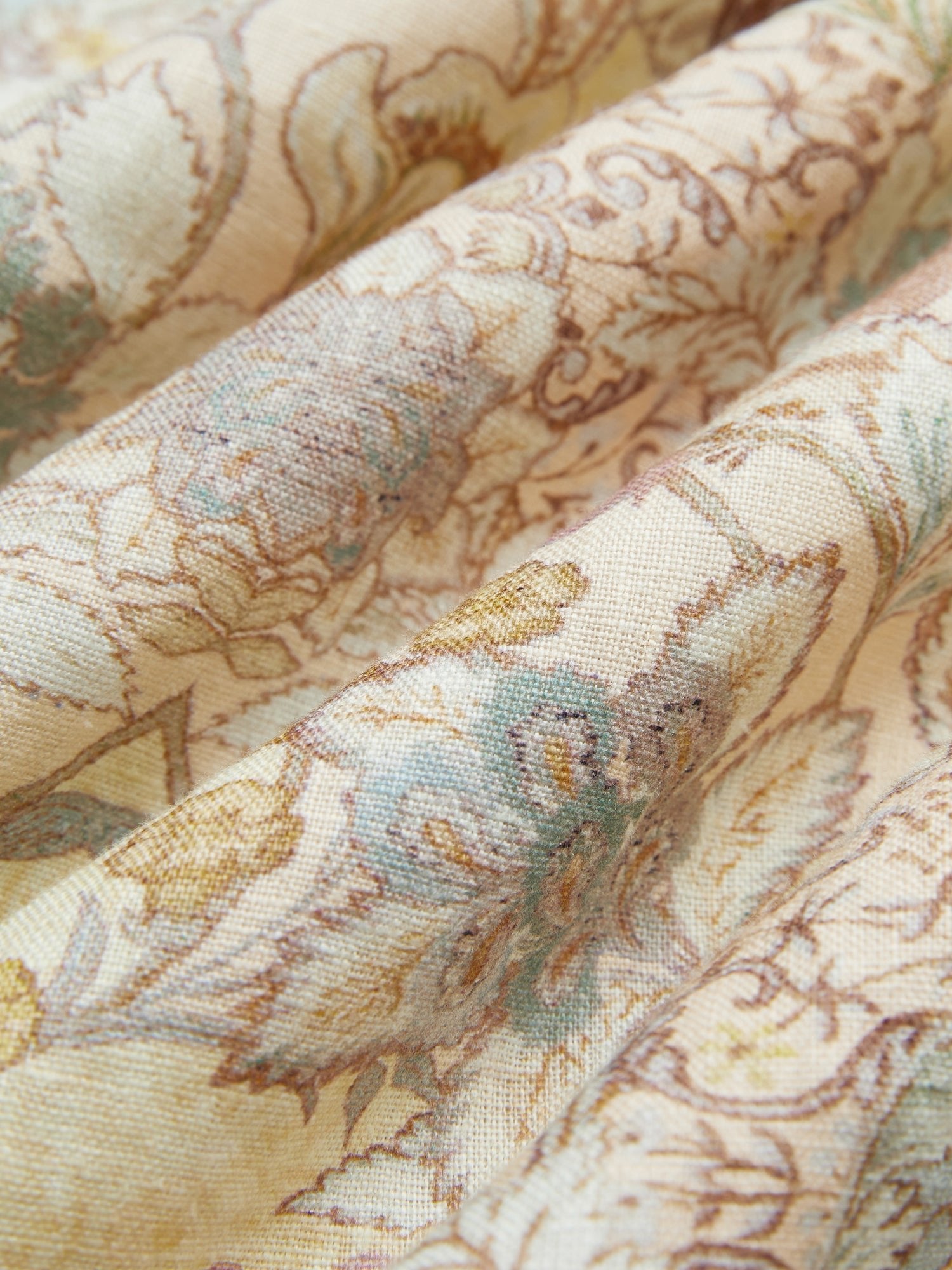 Close-up of Social Queen’s Floral Print Midi Skirt in beige linen, featuring a vintage-inspired floral pattern in soft blue, yellow, and brown tones that showcase the fabric's texture and gentle folds.