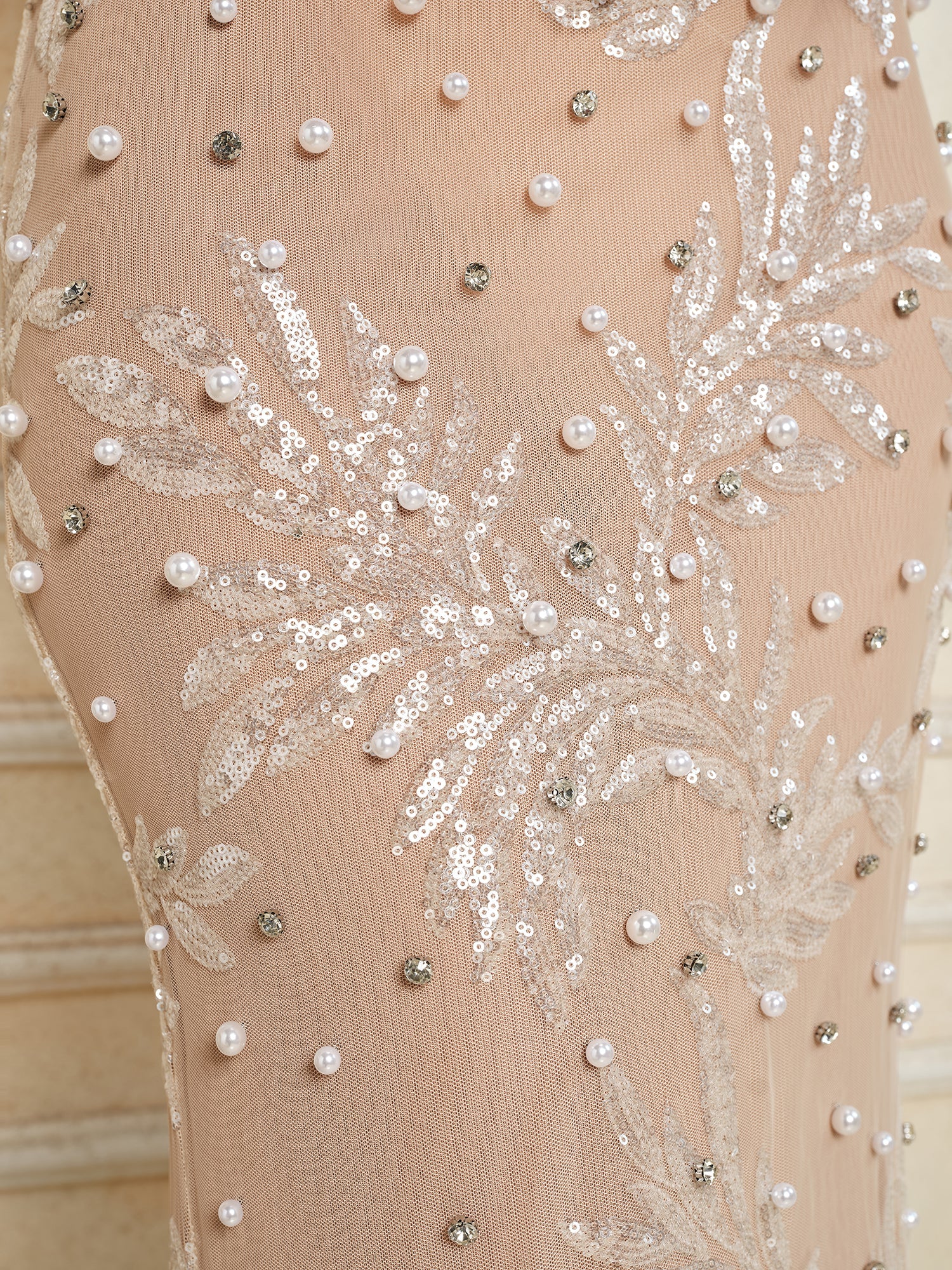Close-up of the Social Queen Hand-Beaded Sequin Embroidered Cocktail Gown, showcasing beige fabric adorned with sequins, leaf embroidery, and pearl-like beading in a decorative arrangement.