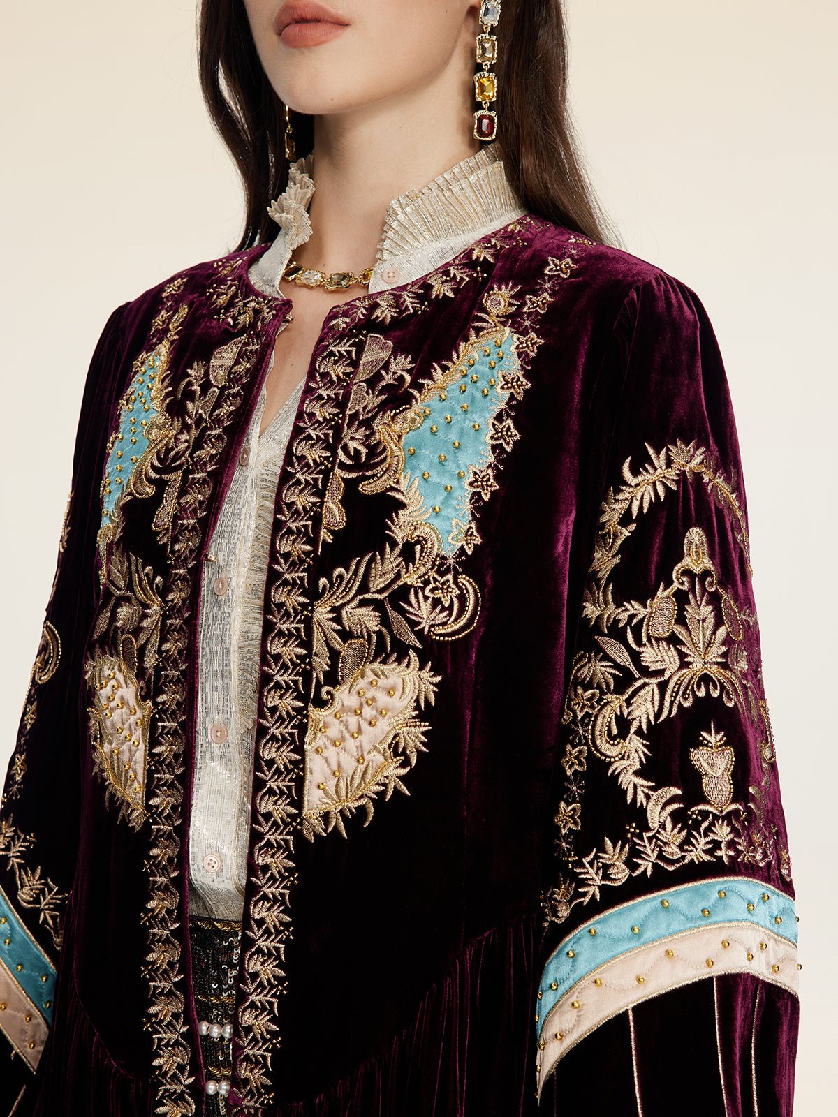 A person wears the Social Queen Handcrafted Embroidered Velvet Jacket over a white shirt, styled with a jeweled necklace, earrings, and vintage-inspired touches.