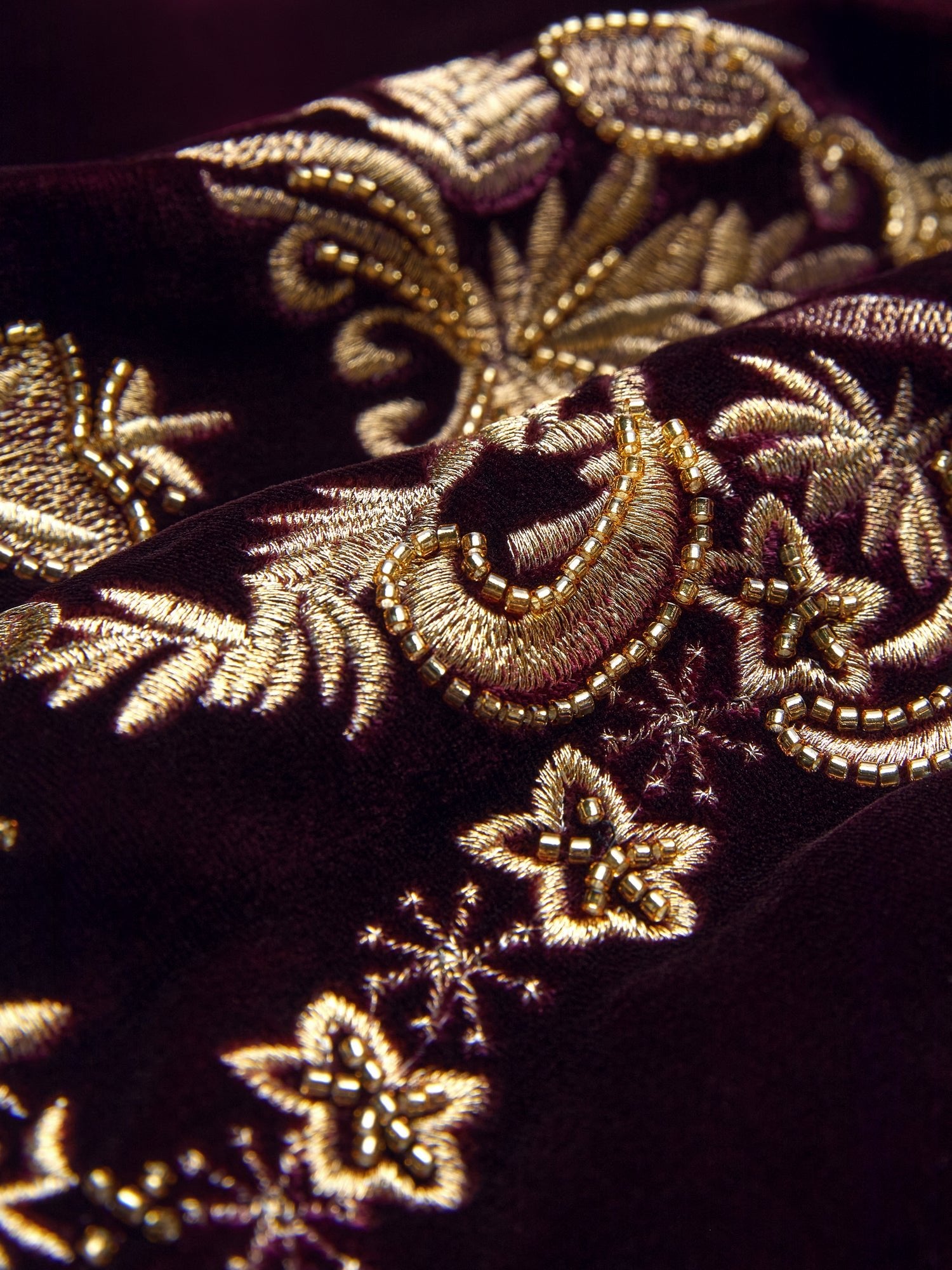 Close-up of the Social Queen Handcrafted Embroidered Velvet Jacket featuring intricate gold floral and paisley embroidery on dark maroon, highlighted by hand-applied pearls for vintage glamour.