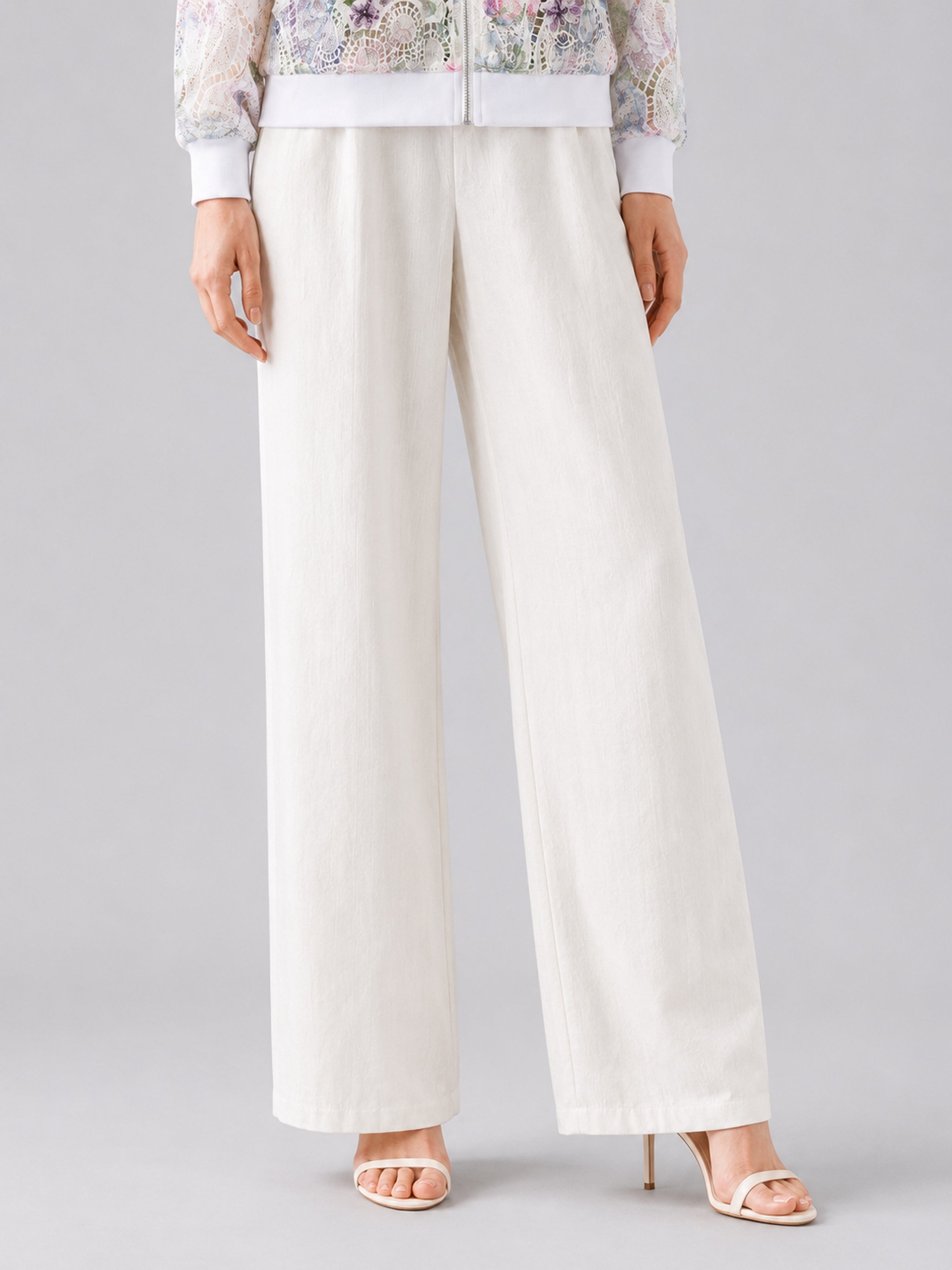 A person wearing Social Queen’s Casual Wide-Leg Pants, featuring a mid-high rise and lyocell-linen blend, paired with open-toe high heels, stands against a plain background, with only the lower half of their body visible.