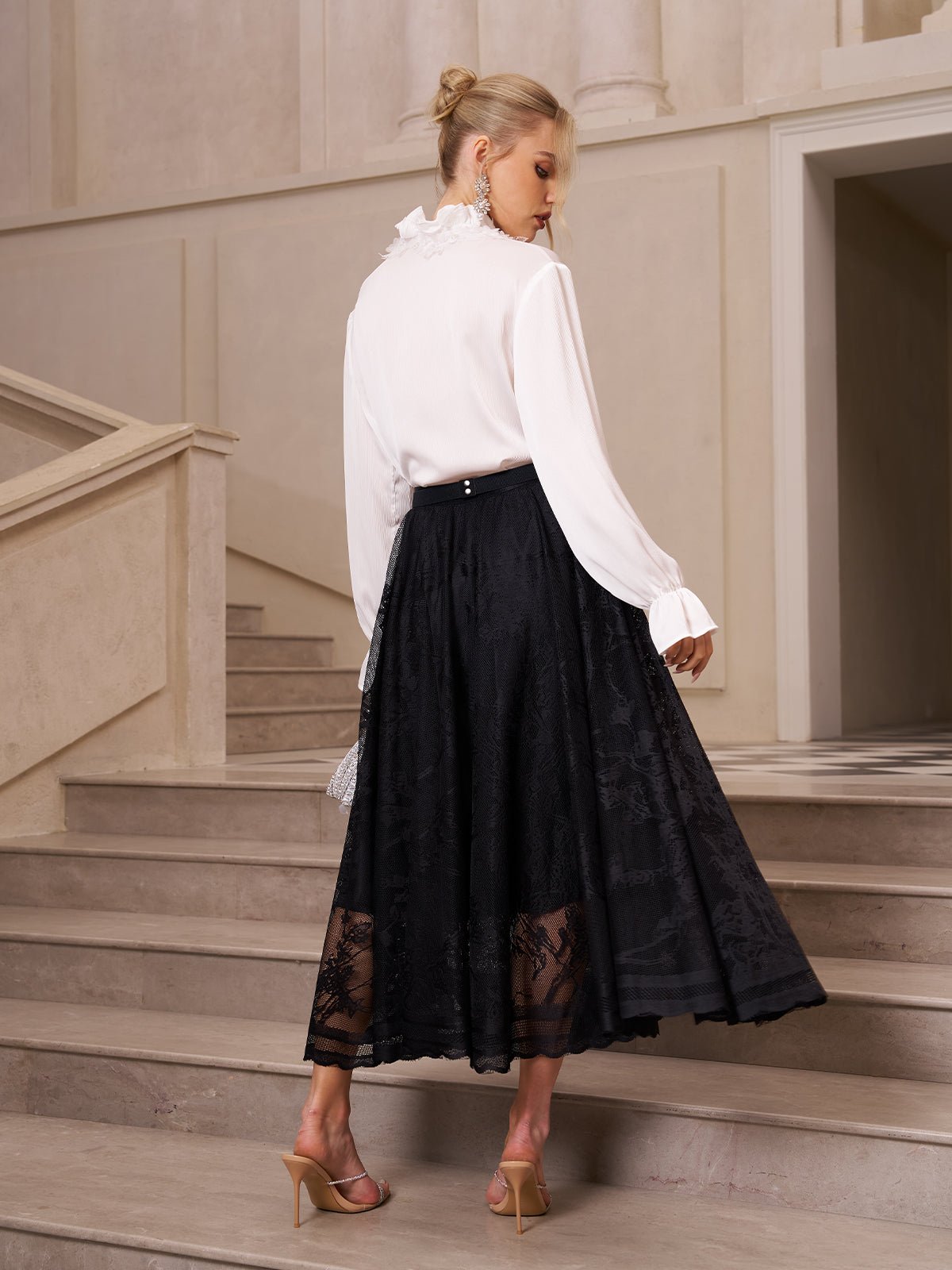 A woman in a white blouse and the Social Queen Jacquard Lace A-Line Midi Skirt stands on stone stairs, facing away.