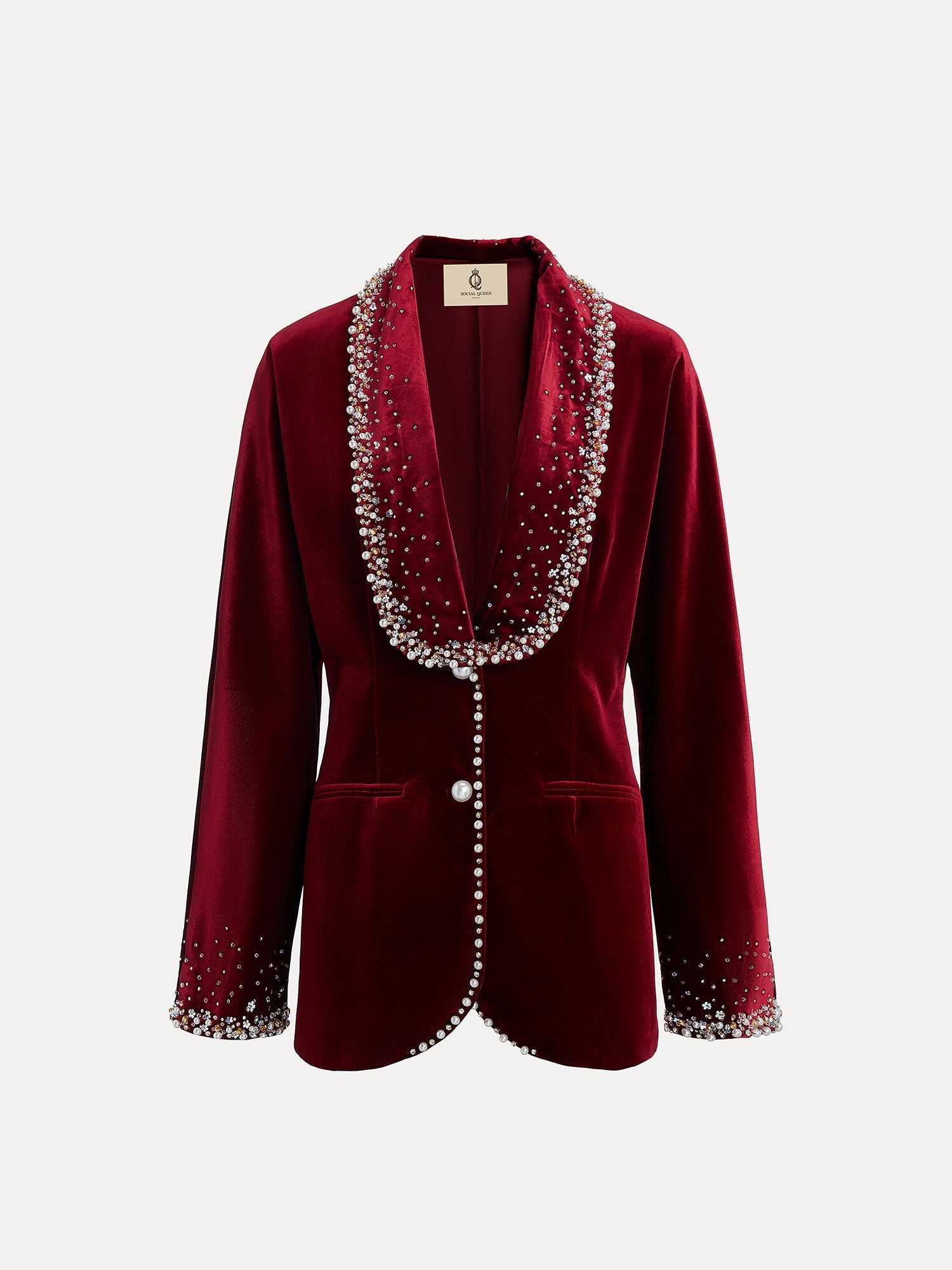 The Pearl & Crystal Velvet Blazer by Social Queen features deep red silk velvet, hand-applied pearls on the collar, cuffs, and front edges, two front pockets, and a single button closure—ideal for wedding guests.