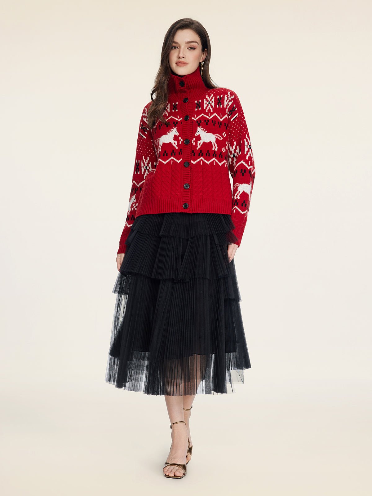 A woman modeling the Social Queen Playful Motif 100% Wool Cardigan with a black tiered tulle skirt and strappy heels stands against a plain background.