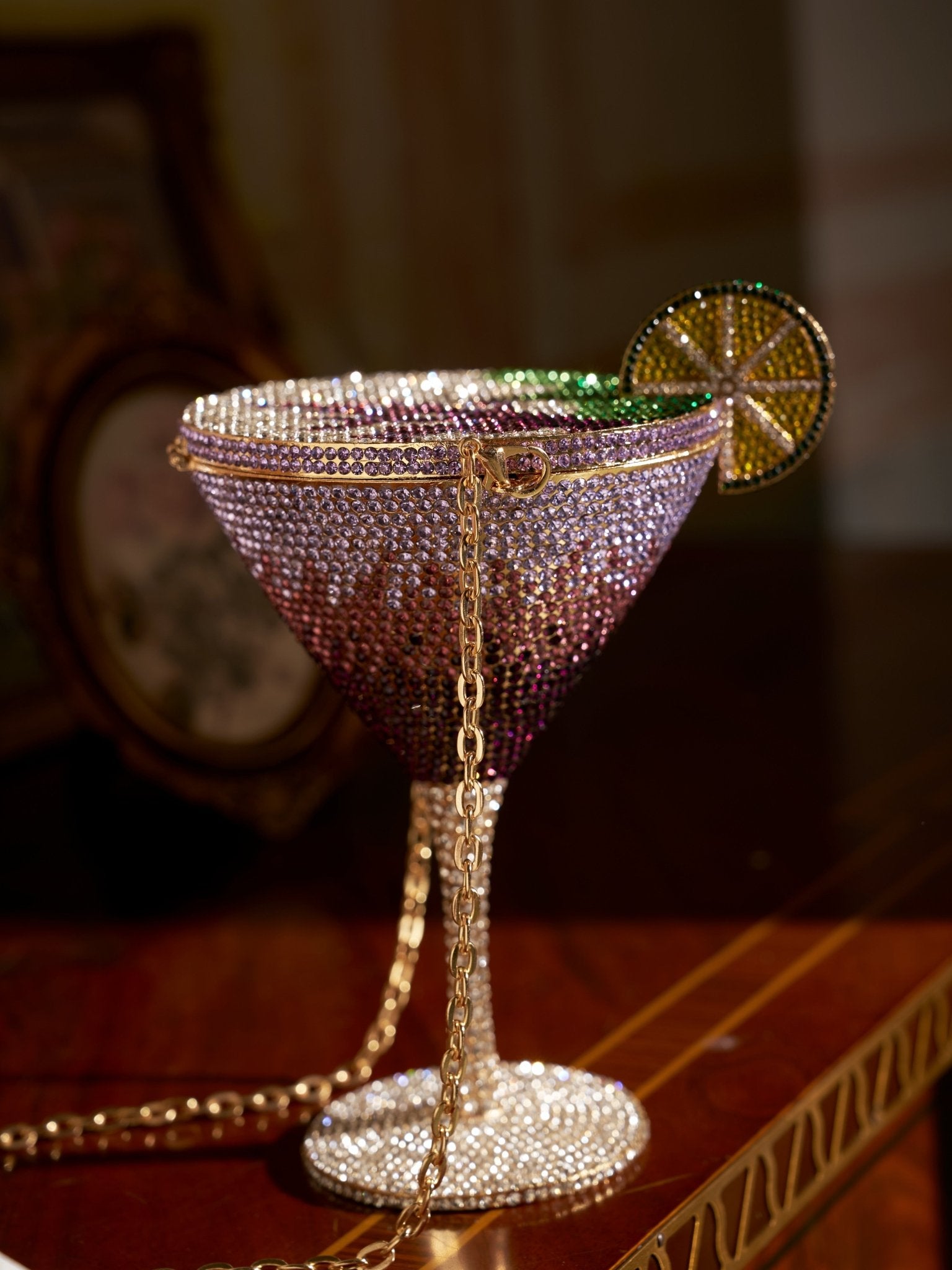 The Social Queen Rhinestone Martini Glass Hardcase Clutch features a jeweled design with a decorative lime slice and gold chain, making it the perfect statement evening bag for your next event.