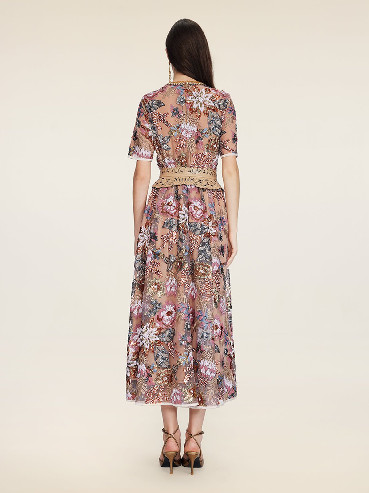 A woman faces away from the camera in the Social Queen Sequin Embellished Floral Dress, paired with high-heeled sandals.