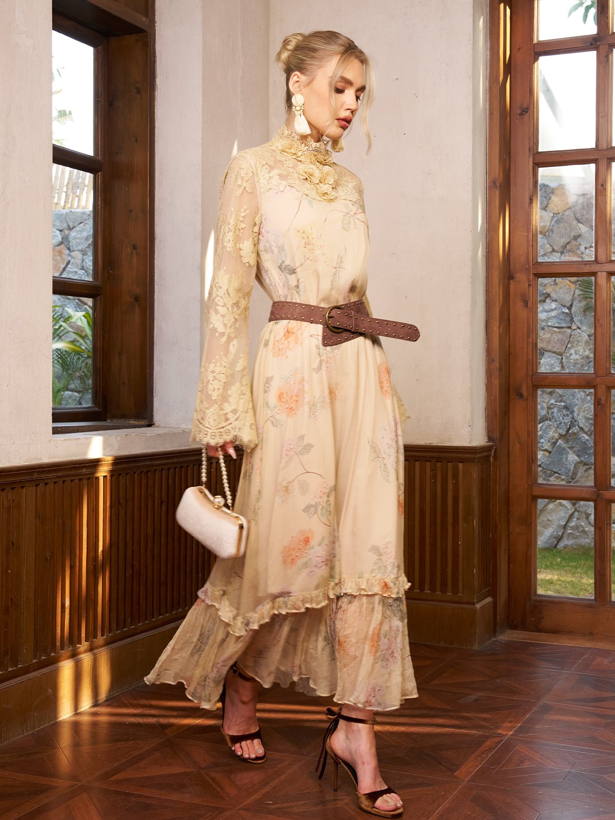 A woman wears the Social Queen Silk Floral & Bird Print Lace Dress, holding a small handbag as she walks indoors on wooden floors near large windows.