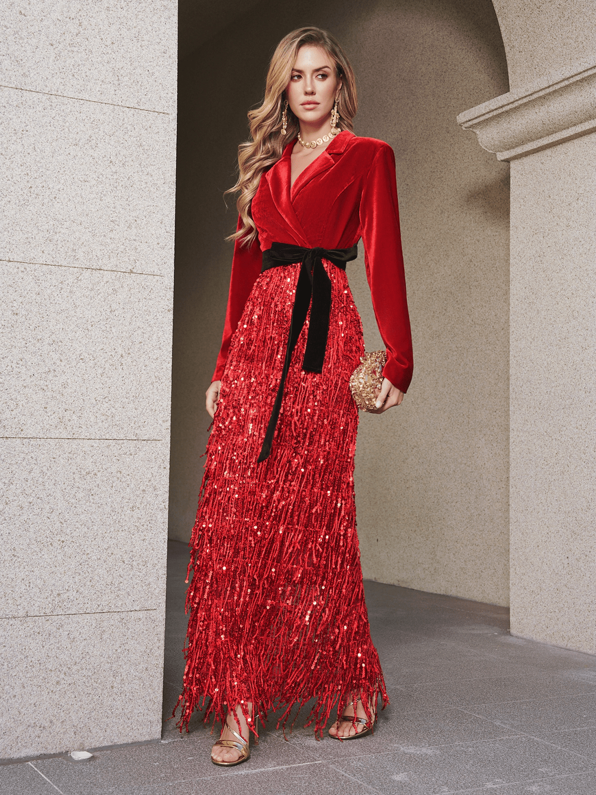 A woman wears the Social Queen Velvet Fringe Sequin Dress, featuring red velvet and sequin fringe details, styled with a gold clutch and strappy heels—ideal for making a chic statement as a wedding guest.