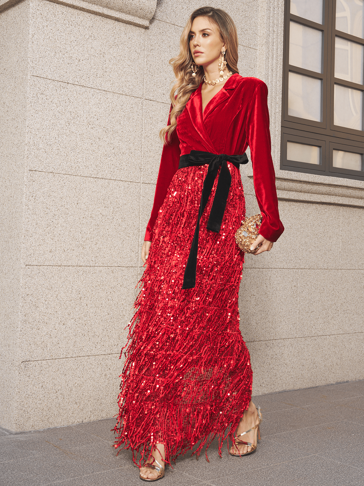 The Social Queen Velvet Fringe Sequin Dress, styled with a black belt and gold clutch, creates a stunning wedding guest look—perfect for strolling past city stone buildings.
