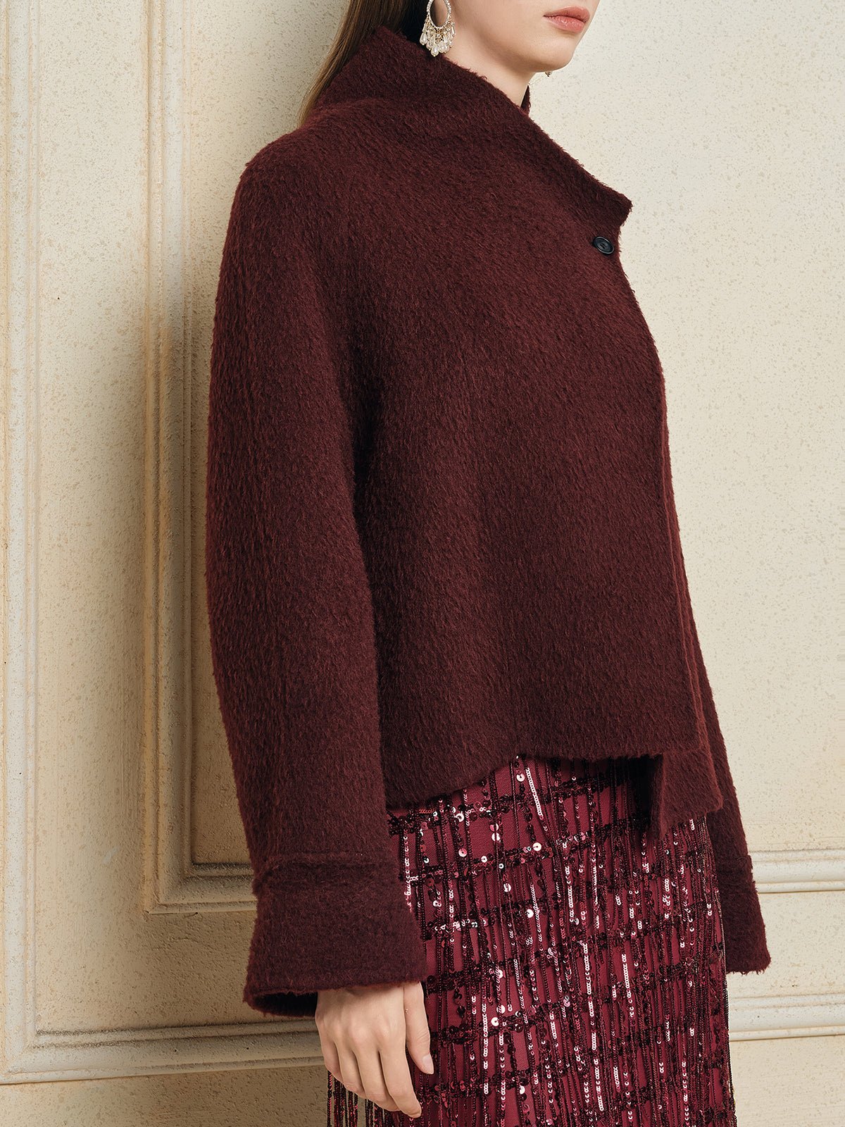 A person wearing the Social Queen Wool-Cashmere Cropped Wrap Jacket over a patterned burgundy skirt stands against a light-colored wall.