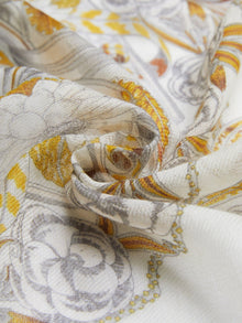 The Social Queen 100% Cashmere Floral Scarf features a vintage-inspired yellow, grey, and white floral swirl pattern on lightweight sheer cashmere, shown loosely gathered at the center.