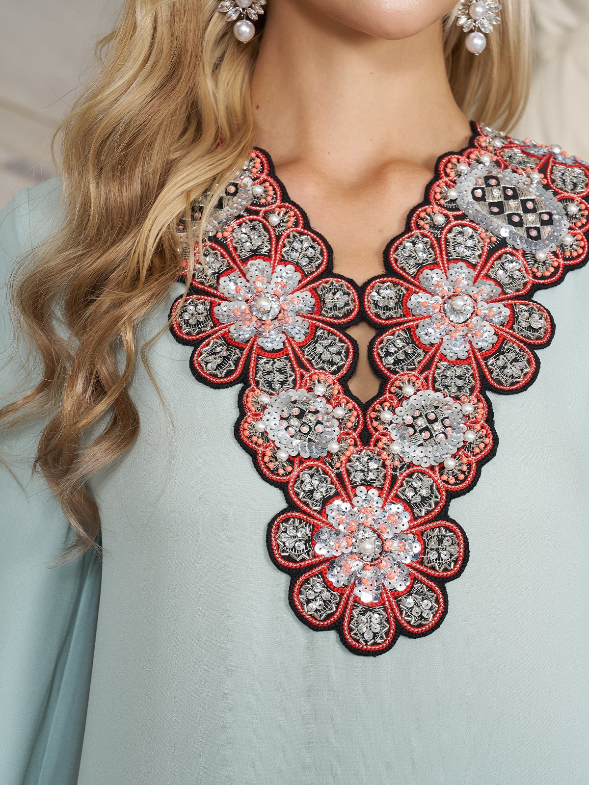 Close-up of a woman wearing the Social Queen 100% Mulberry Silk Feather Limited Dress in light blue, featuring intricate floral beadwork and embroidery at the neckline. Only her neck, part of her chest, and hair are visible.