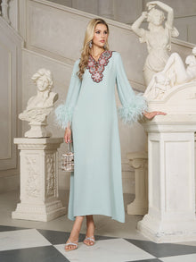 A woman in a light blue dress with feathered sleeves and floral neckline detail stands in a classical marble hall with white statues.