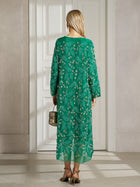 A woman stands indoors facing a white door, wearing the Social Queen 100% Silk Beaded Embroidery Dress, holding a small handbag and wearing heeled sandals.