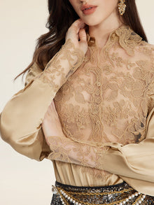 A woman in the Social Queen 100% Silk Embroidered Lace Satin Blouse crosses her arms, accessorizing with gold earrings and a pearl-decorated belt.