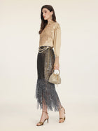 A woman in profile wears the Social Queen 100% Silk Embroidered Lace Satin Blouse, a black sequin fringe skirt, gold heels, statement earrings, and carries a small gold handbag with pearl details.
