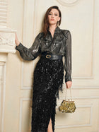 Indoors, a woman wears Social Queen’s 100% Silk Luminous Metallic Ruffle Blouse, paired with a black sequined skirt, wide belt, and a small gold handbag.