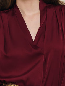 Close-up of a person wearing the Social Queen 100% Silk Satin Wrap V-Neck Blouse in deep red, highlighting its smooth, luxurious texture and elegant cross-front design.