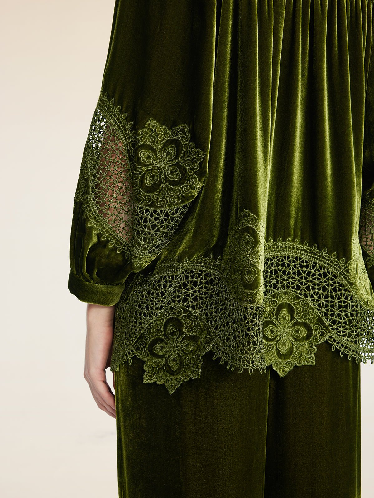 A person wears the Social Queen 100% Silk Velvet Lace-Panel Blouse, featuring hand-stitched lace on the sleeve and hem. Only the back of the upper body and part of one arm are shown.