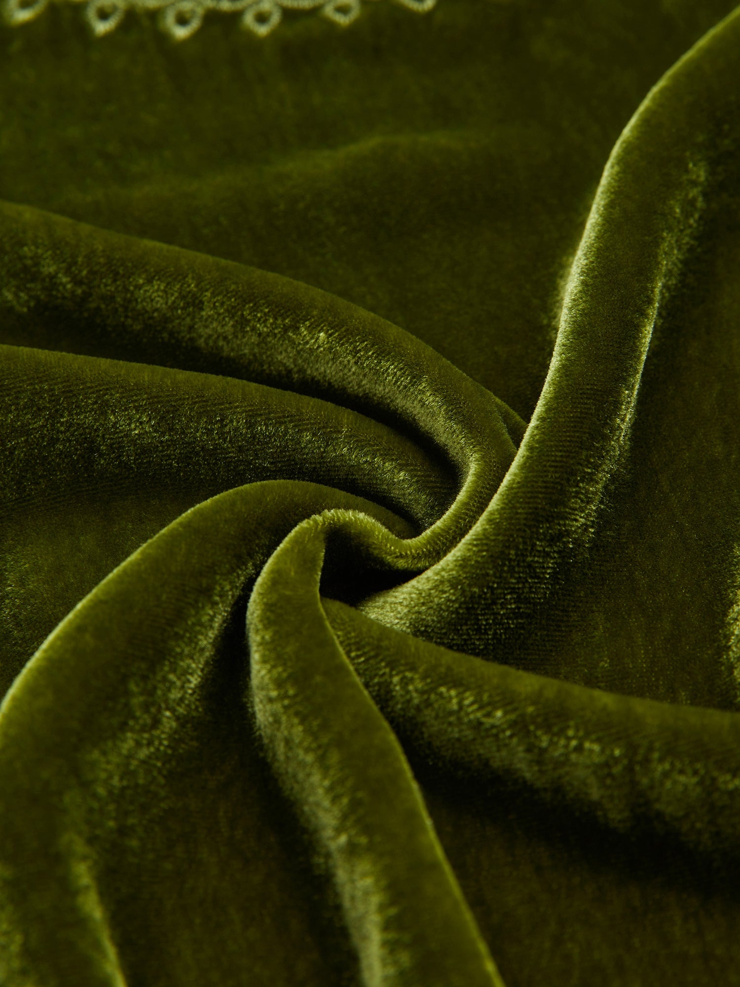 Close-up of the Social Queen 100% Silk Velvet Lace-Panel Blouse in green, highlighting its soft texture, twisted fold, and subtle light reflections for a vintage luxe feel.