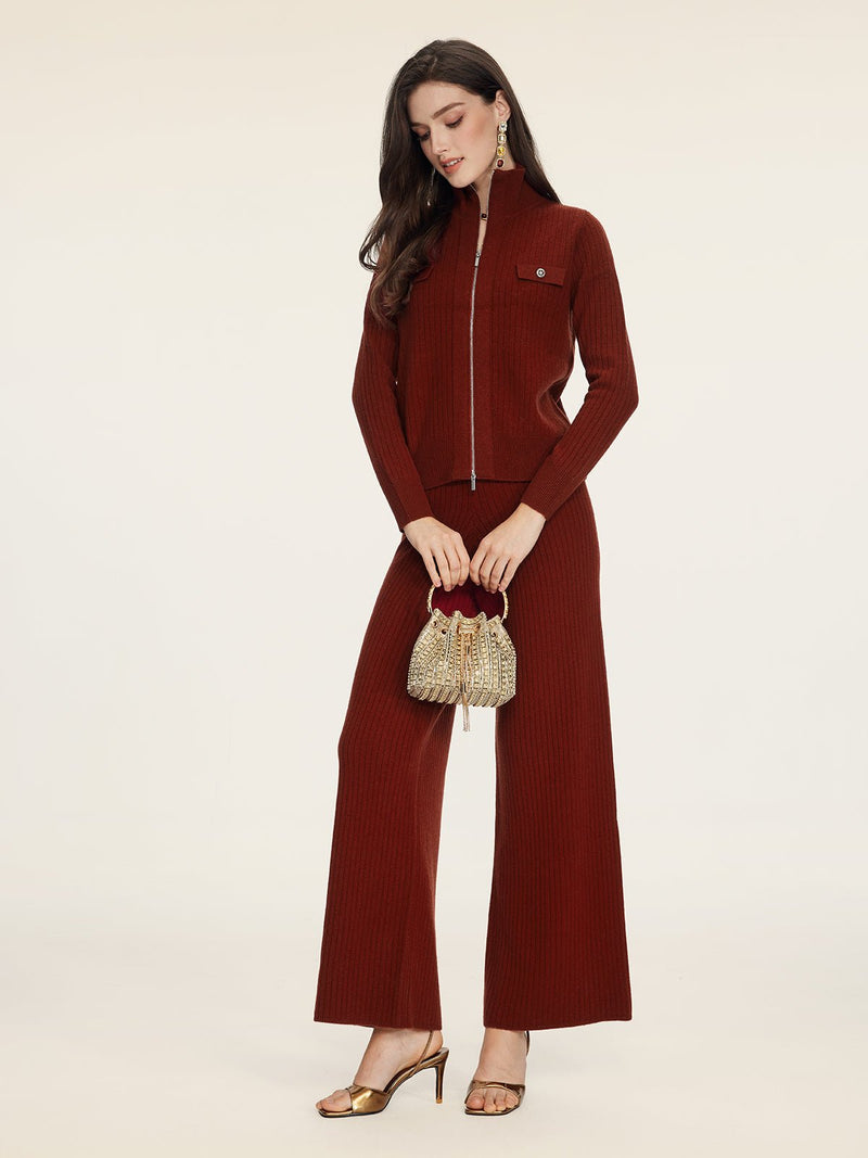 A woman wears the Social Queen 100% Wool Knit Jacket in rust, featuring hand-optimized zippers and matching wide-leg pants, styled with a small gold purse and gold high-heeled sandals.