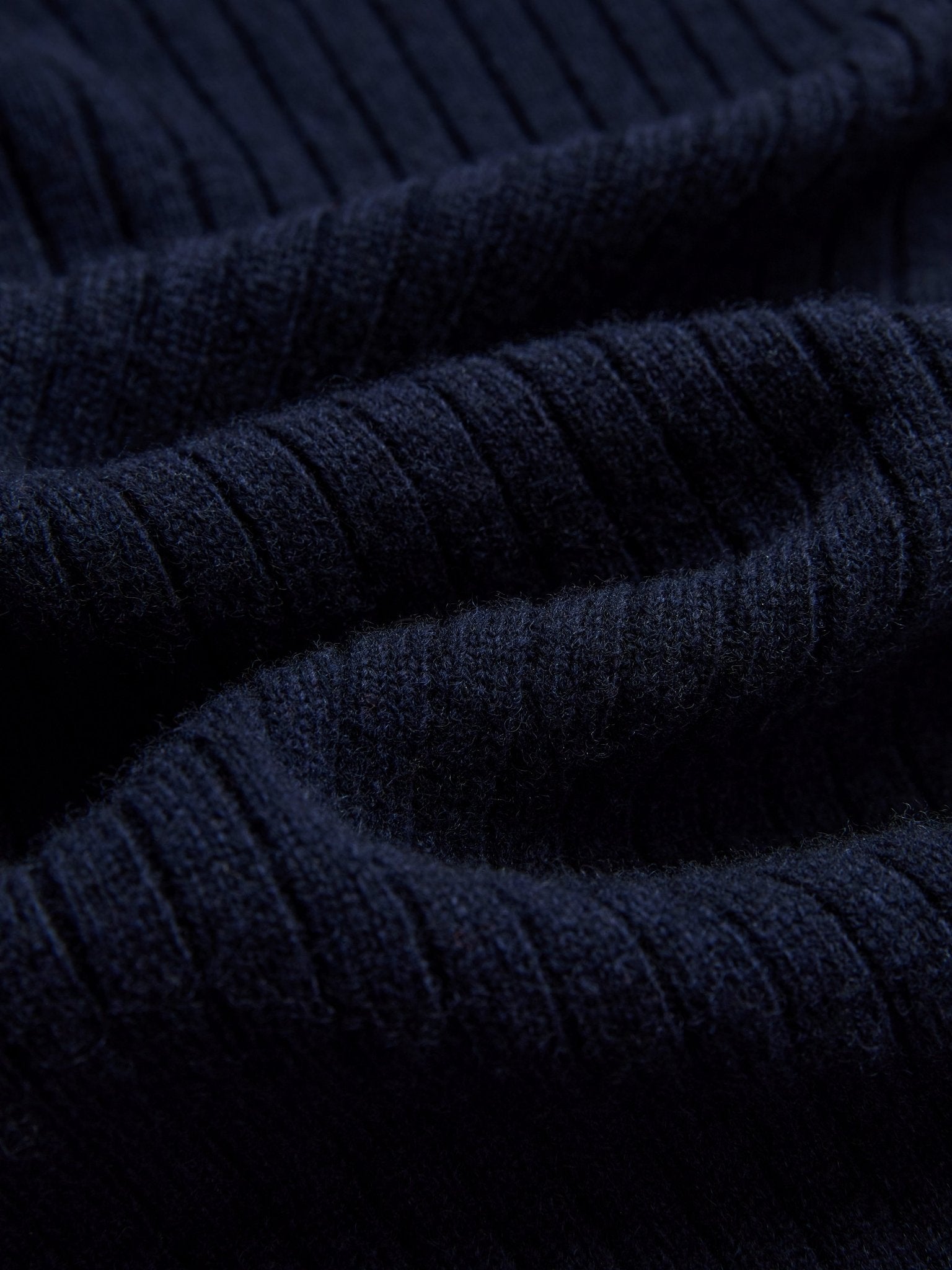 Close-up of dark navy blue ribbed knit fabric with a soft texture from Social Queen’s 100% Wool Knit Jacket. Ideal for warmth and style.