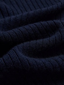 Close-up of dark navy blue ribbed knit fabric with a soft texture from Social Queen’s 100% Wool Knit Jacket. Ideal for warmth and style.