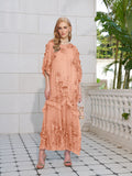 A woman in the Social Queen Rose Appliqué 100% Mulberry Silk Dress and heels stands on a tiled floor beside a white stone railing and green plants.