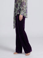 Social Queen velvet wide-leg pants in purple, styled with a green and purple floral blouse and tan heels.