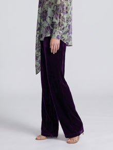 Social Queen velvet wide-leg pants in purple, styled with a green and purple floral blouse and tan heels.