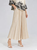 A woman models the Social Queen Striped Pleated Wide-Leg Pants, featuring subtle vertical stripes, paired with cream heeled sandals and a short-sleeve top with a black floral print. Her hands rest in the pants’ pockets against a plain grey background.