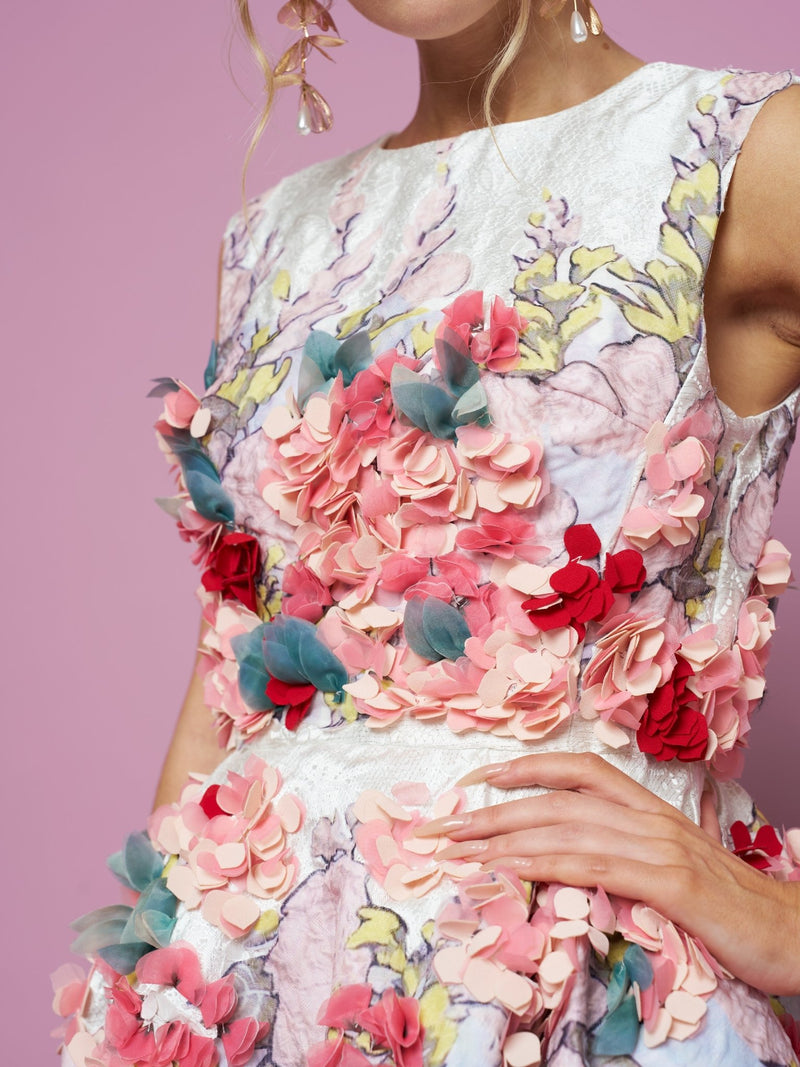 Model wearing the Social Queen 3D Floral Embellished Jacquard Gown, featuring pink, red, and teal floral accents on pastel-patterned satin, set against a pink background.