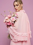 A woman in the Social Queen 3D Floral Embellished Silk Dress holds a bouquet of pink flowers against a pastel pink background.