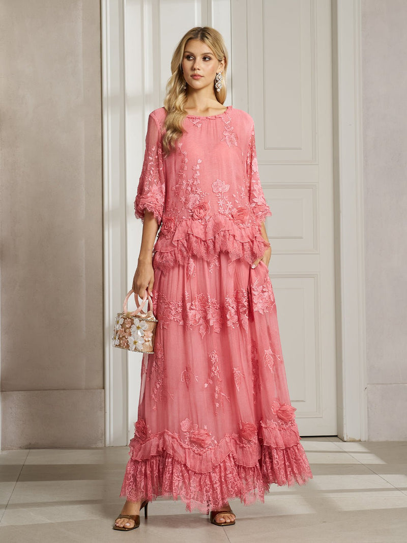A woman stands indoors wearing the Social Queen 3D Floral Embroidered 100% Silk Ruffle Blouse, paired with a small floral handbag, long earrings, and heeled sandals.