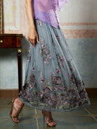 A person stands on a tiled floor in heeled sandals, wearing a sheer purple top and the Social Queen 3D Floral Embroidered Silk Skirt.