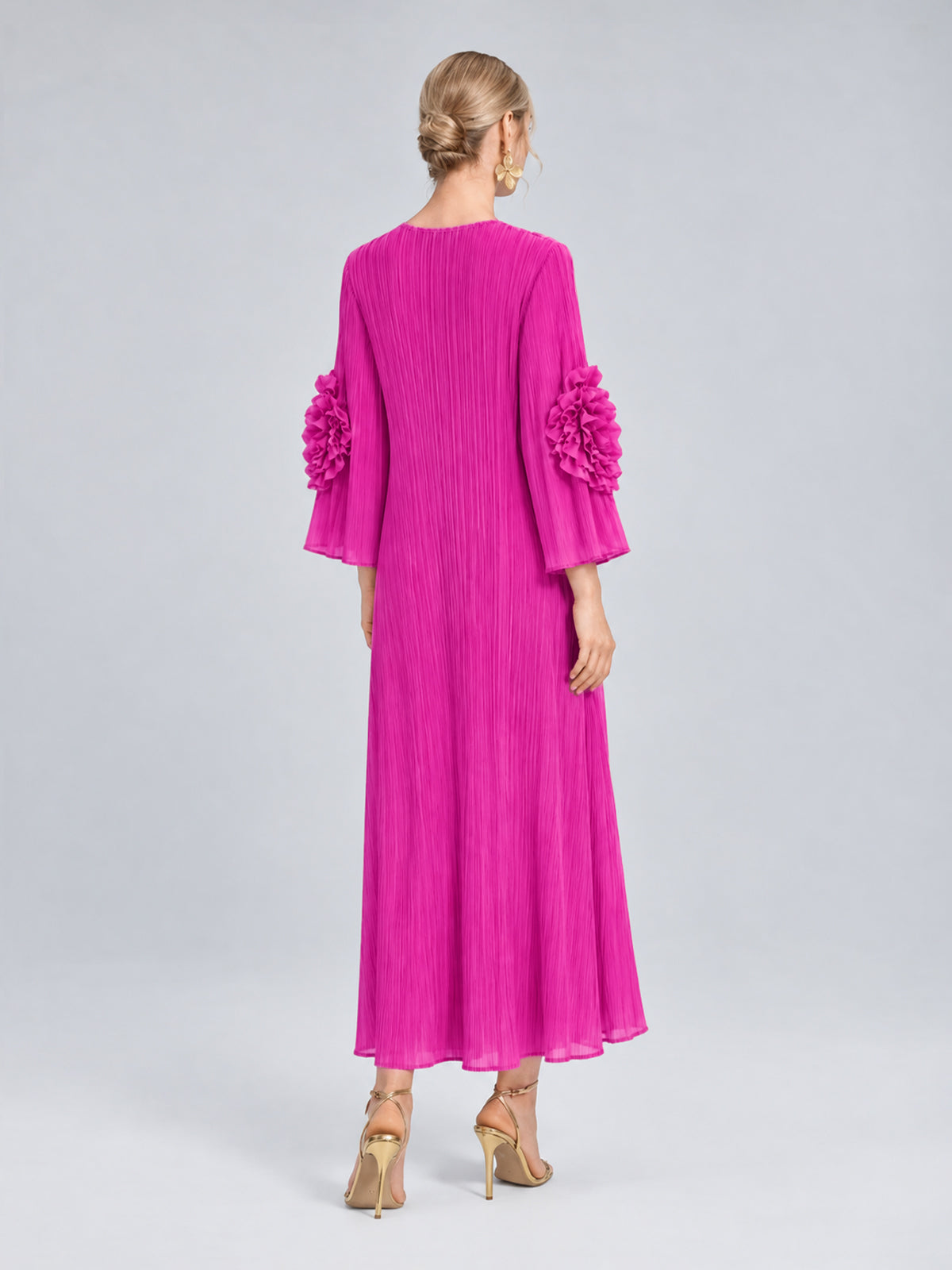 A model showcases the Social Queen 3D Floral Pleated Dress—a vibrant pink midi design featuring ruffled sleeve accents and intricate floral appliqué—facing away from the camera in heels against a plain light gray background.