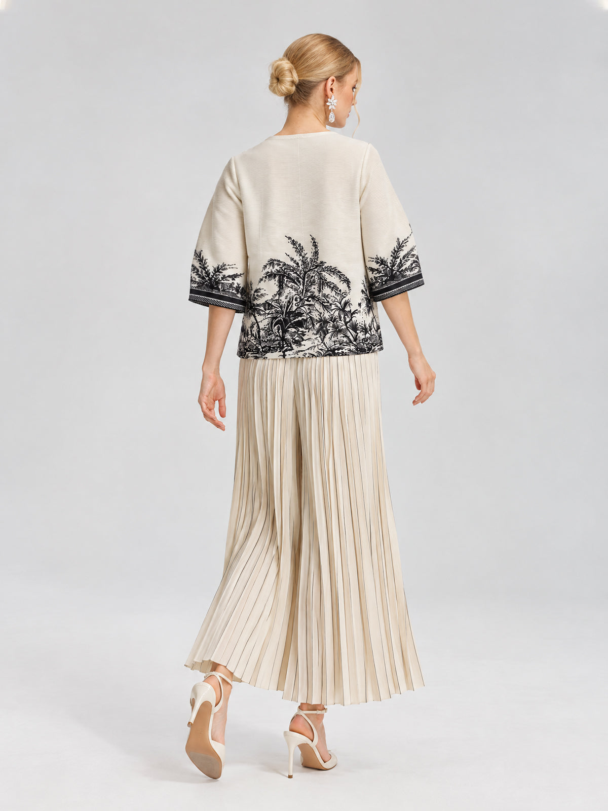A woman, seen from behind in a cropped silhouette as she walks against a light gray background, wears the Social Queen Palm Tree Print Pleated Blouse paired with a cream skirt.