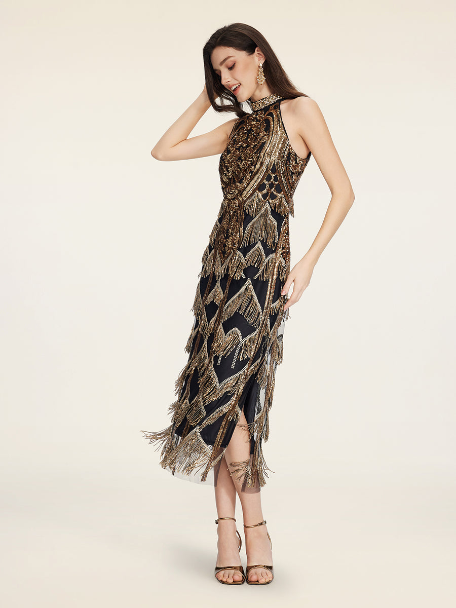 A woman stands in a sleeveless, knee-length black dress with gold and silver sequin patterns and fringe, wearing strappy heels, earrings, and looking down with one hand in her hair.