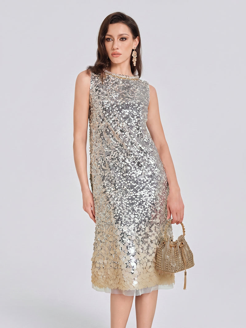 A woman wears the Social Queen Ombre Silver & Gold Sequin Embellished Dress, a sleeveless knee-length style that shines with gradient sequins, pairing it with a small gold handbag—the perfect choice for a standout party look or an elegant wedding guest outfit.