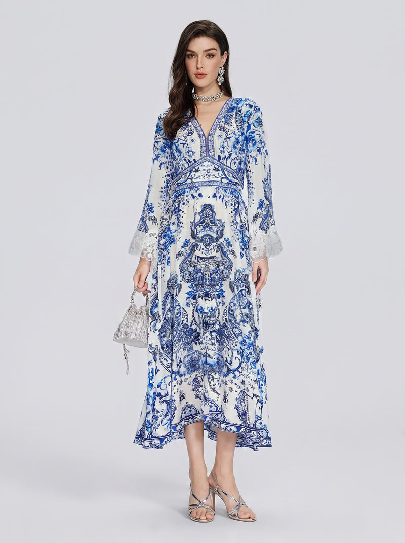 A woman is standing against a plain light background wearing the Social Queen Floral Embroidered Lantern Sleeve Dress, styled with a small silver handbag, silver sandals, and matching jewelry.