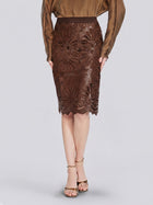 A person wearing a brown long-sleeve blouse, the Social Queen Openwork Embroidered Leather Skirt, and beige heeled sandals stands against a plain light gray background.