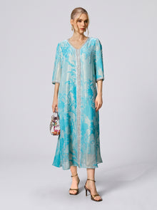 A woman wearing the Social Queen Embellished Velvet Burnout Silk Dress stands against a plain background, holding a small handbag and wearing heeled sandals.