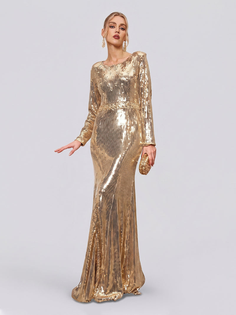 A woman poses in the Social Queen Beaded Gold-Accent Crystal Gown, a long-sleeved, floor-length sequin evening dress. She accessorizes with a matching gold clutch and drop earrings against a plain light background, radiating elegance and glamour as the perfect formal wedding guest.